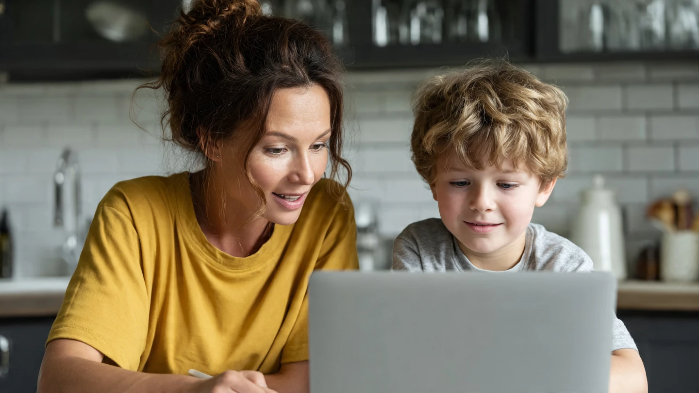 Madre joven solicitando la ayuda por hijo a cargo 2026 desde su portátil con su bebé